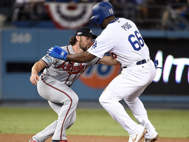 LOS ANGELES, CA - OCTOBER 05: Yasiel Puig #66 of the Los Angeles Dodgers is caught stealing by Charlie Culberson #16 of the Atlanta Braves during the sixth inning during Game Two of the National League Division Series at Dodger Stadium on October 5, 2018 in Los Angeles, California.