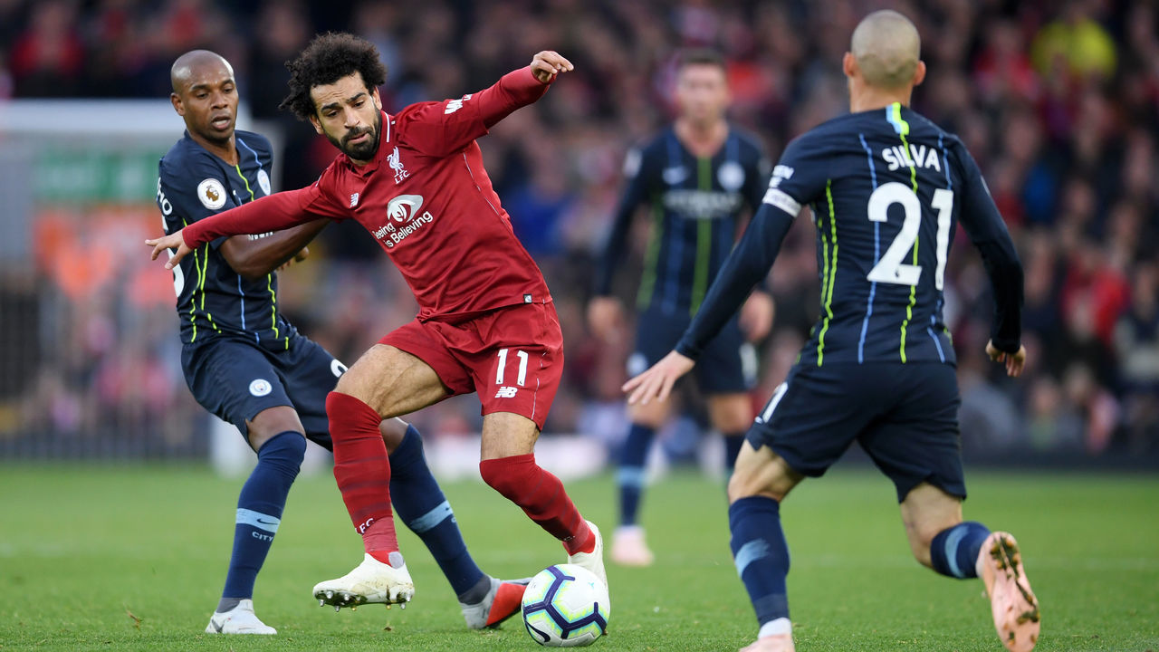 LIVERPOOL, ENGLAND - OCTOBER 07: Mohamed Salah of Liverpool controls the ball under pressure from Fernandinho and David Silva of Manchester City during the Premier League match between Liverpool FC and Manchester City at Anfield on October 7, 2018 in Liverpool, United Kingdom.