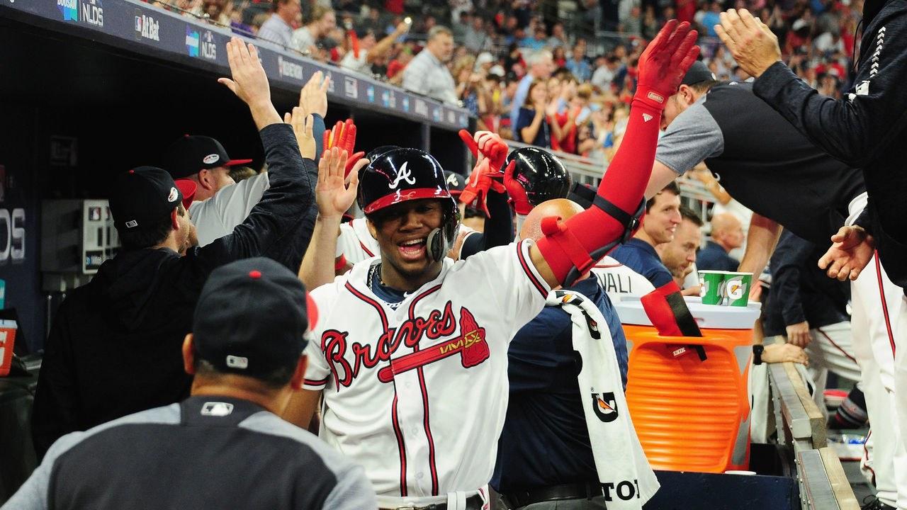 ATLANTA, GA - OCTOBER 07: Ronald Acuna Jr. #13 of the Atlanta Braves celebrates with teammates in the dugout after hitting a grand slam home run in the second inning against the Los Angeles Dodgers during Game Three of the National League Division Series at SunTrust Park on October 7, 2018 in Atlanta, Georgia.
