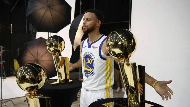 OAKLAND, CA - SEPTEMBER 24: Stephen Curry #30 of the Golden State Warriors poses with three Larry O'Brien NBA Championship Trophies during the Golden State Warriors media day on September 24, 2018 in Oakland, California.