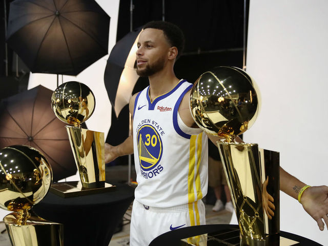 OAKLAND, CA - SEPTEMBER 24: Stephen Curry #30 of the Golden State Warriors poses with three Larry O'Brien NBA Championship Trophies during the Golden State Warriors media day on September 24, 2018 in Oakland, California.
