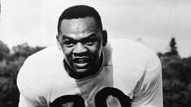 New York Yanks quarterback George Taliaferro, 1949 Rookie of The Year, runs on the field, carrying a football, circa 1949.