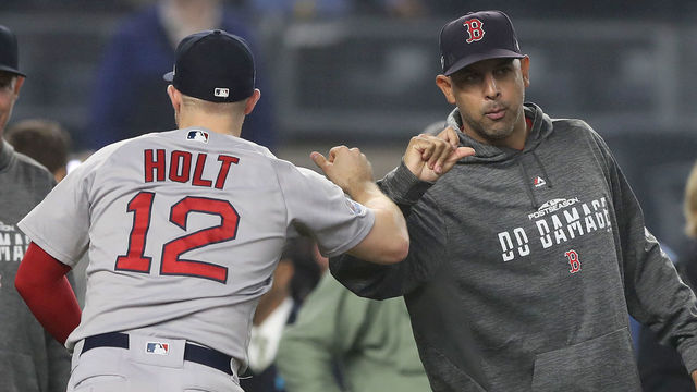 NEW YORK, NEW YORK - OCTOBER 08: Brock Holt #12 and manager Alex Cora #20 of the Boston Red Sox celebrate after defeating the New York Yankees in Game Three of the American League Division Series at Yankee Stadium on October 08, 2018 in the Bronx borough of New York City.