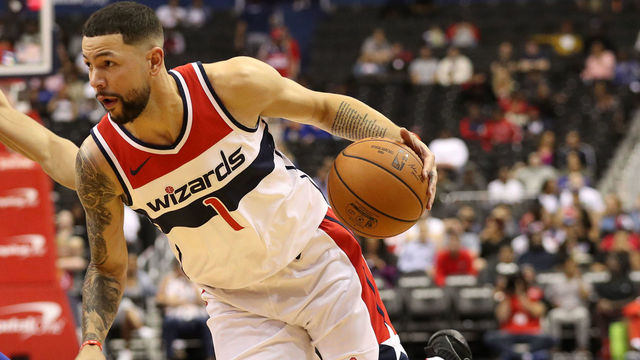 WASHINGTON, DC - OCTOBER 01: Austin Rivers #1 of the Washington Wizards dribbles in front of Kevin Knox #20 of the New York Knicks during the first half of a preseason NBA game at Capital One Arena on October 01, 2018 in Washington, DC.