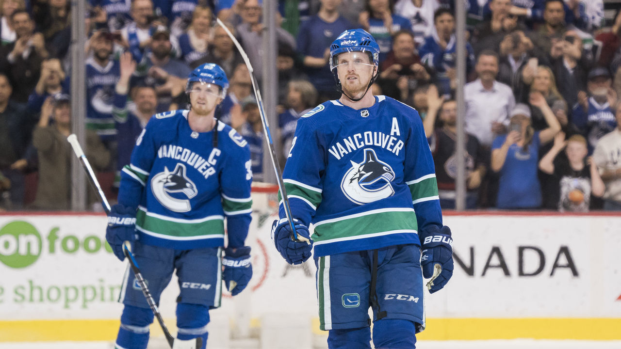 VANCOUVER, BC - OCTOBER 5: Daniel Sedin #22 and Henrik Sedin #33 of the Vancouver Canucks salute the fans after playing in their final home game of their career against the Arizona Coyotes in NHL action on April, 5, 2018 at Rogers Arena in Vancouver, British Columbia, Canada.