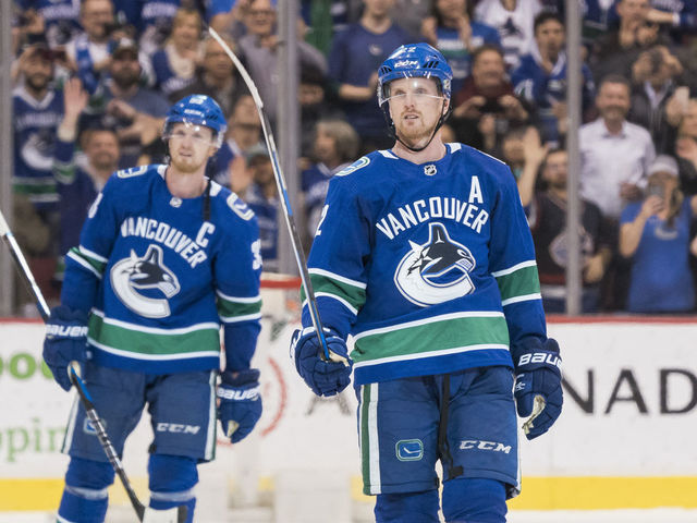 VANCOUVER, BC - OCTOBER 5: Daniel Sedin #22 and Henrik Sedin #33 of the Vancouver Canucks salute the fans after playing in their final home game of their career against the Arizona Coyotes in NHL action on April, 5, 2018 at Rogers Arena in Vancouver, British Columbia, Canada.
