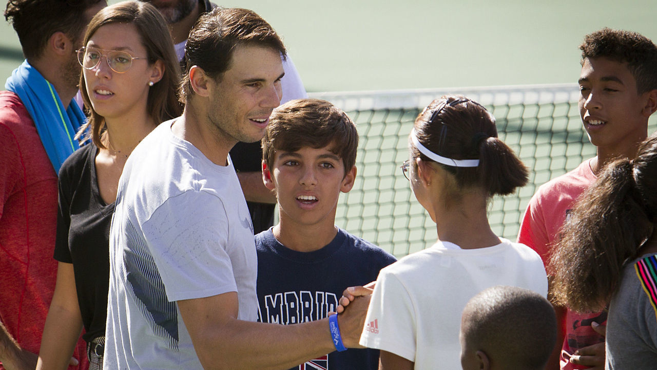 Spanish tennis player Rafa Nadal (L) greets students of the 'Rafa Nadal Academy' in Manacor after observing a minute of silence on October 11, 2018 to honour the victims of the flash flood that affected the Spanish Balearic island of Majorca. - Hundreds of rescue workers searched desperately today for a five-year-old boy and two Germans still missing on Spain's holiday island of Majorca after flash floods tore through streets and swept away cars, killing 10 people.