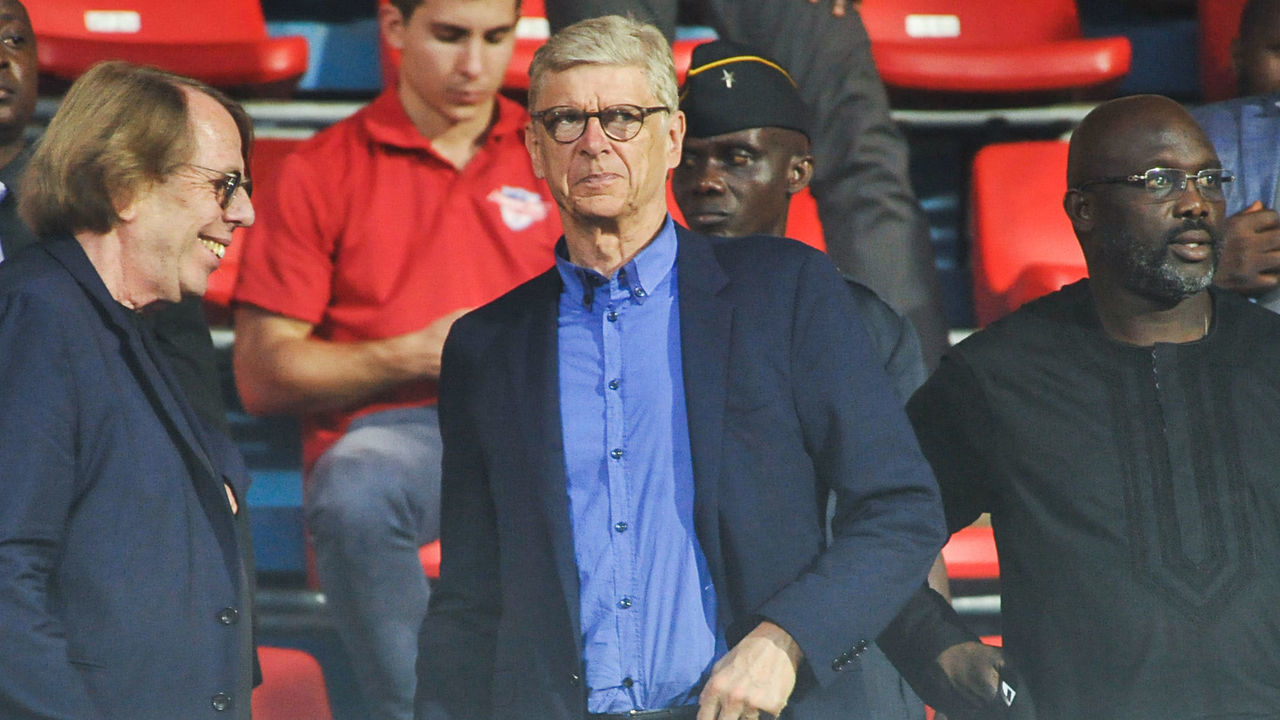 (From L) Former French football players and coaches Claude LeRoy and Arsene Wenger arrive with Liberian President George Weah at the stadium to attend a football match in Monrovia on August 23, 2018. - Liberian President George Weah gave on August 24, 2018 his country's top honour to Arsene Wenger and Claude LeRoy, the two French coaches who gave his football career an early boost.