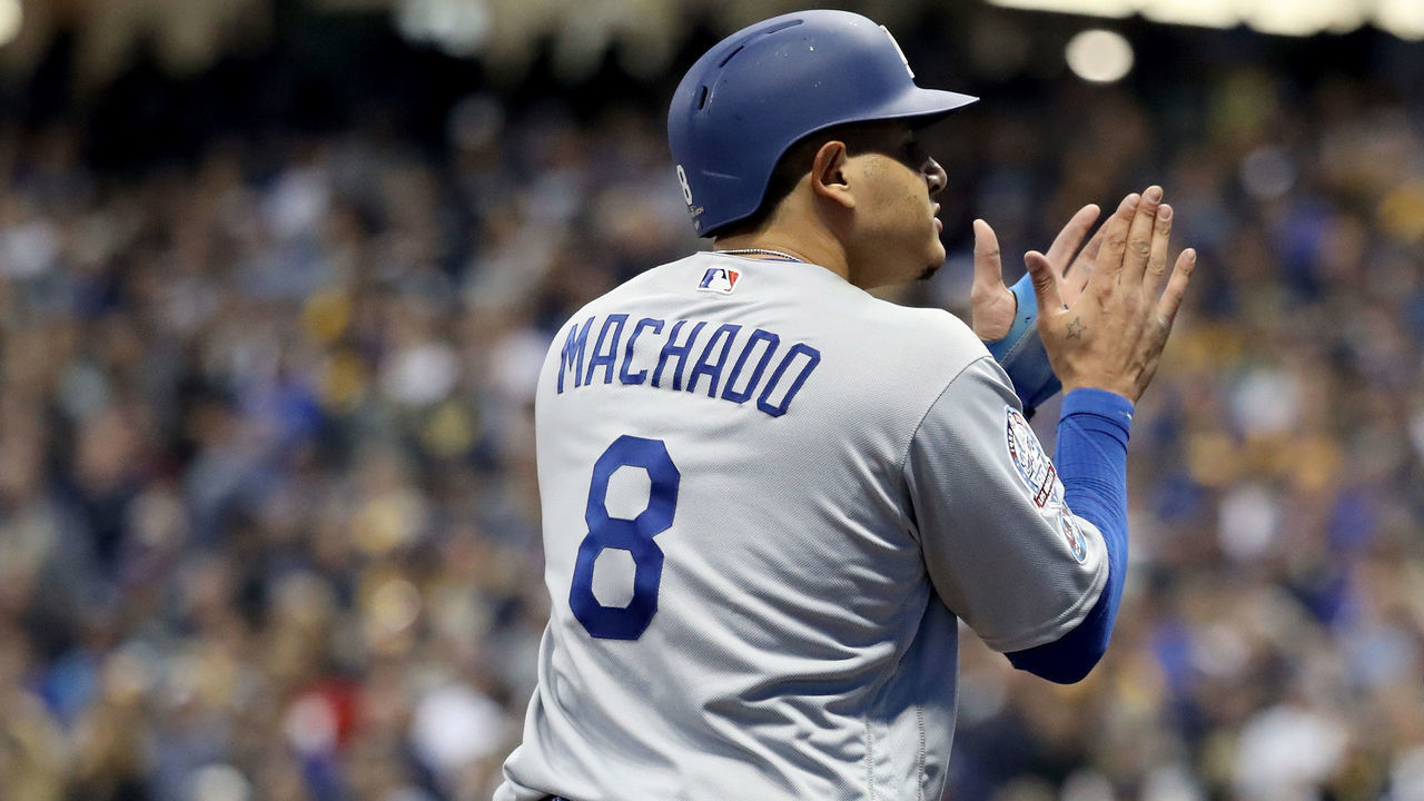 MILWAUKEE, WI - OCTOBER 12: Manny Machado #8 of the Los Angeles Dodgers celebrates after hitting an RBI single to score Chris Taylor #3 and Joc Pederson #31 against the Milwaukee Brewers during the eighth inning in Game One of the National League Championship Series at Miller Park on October 12, 2018 in Milwaukee, Wisconsin.