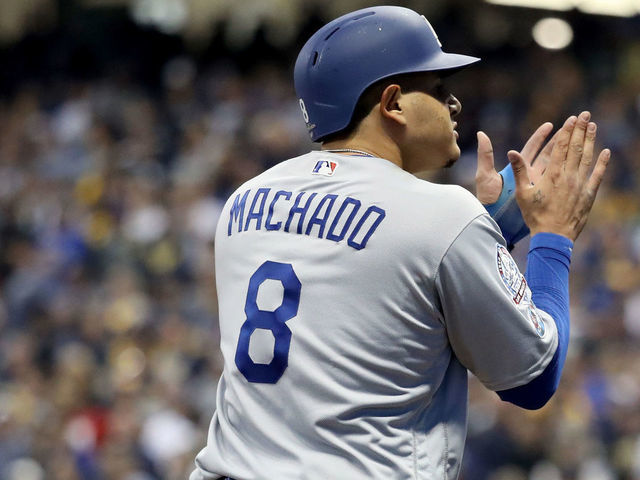 MILWAUKEE, WI - OCTOBER 12: Manny Machado #8 of the Los Angeles Dodgers celebrates after hitting an RBI single to score Chris Taylor #3 and Joc Pederson #31 against the Milwaukee Brewers during the eighth inning in Game One of the National League Championship Series at Miller Park on October 12, 2018 in Milwaukee, Wisconsin.
