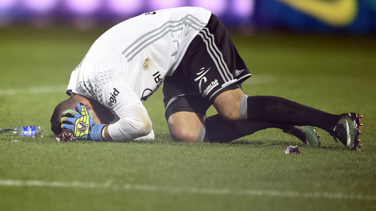 Lyon's Portuguese goalkeeper Anthony Lopes reacts after a firecracker exploded beside him during the French L1 football match between Metz (FCM) and Lyon (OL) on December 3, 2016 at Saint Symphorien stadium in Longeville-Les-Metz, eastern France / AFP / JEAN-CHRISTOPHE VERHAEGEN