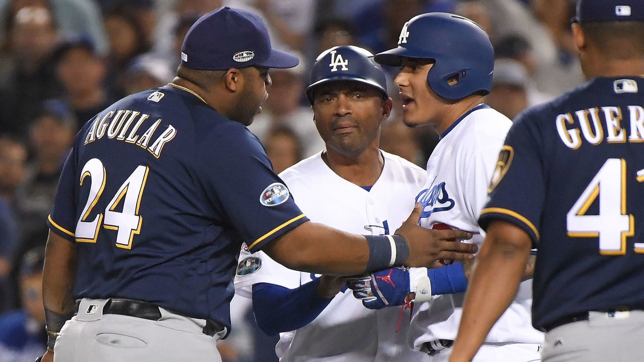 LOS ANGELES, CA - OCTOBER 16: Manny Machado #8 of the Los Angeles Dodgers and Jesus Aguilar #24 of the Milwaukee Brewers exchange words during the tenth inning in Game Four of the National League Championship Series at Dodger Stadium on October 16, 2018 in Los Angeles, California.