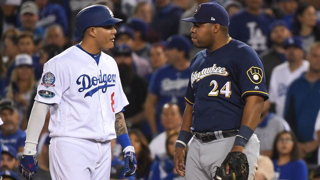 LOS ANGELES, CA - OCTOBER 16: Manny Machado #8 of the Los Angeles Dodgers and Jesus Aguilar #24 of the Milwaukee Brewers exchange words during the tenth inning in Game Four of the National League Championship Series at Dodger Stadium on October 16, 2018 in Los Angeles, California.