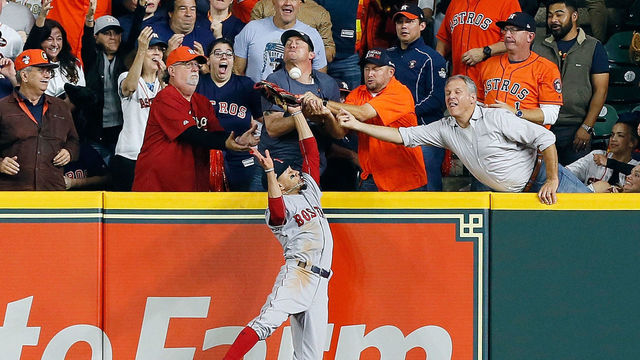 HOUSTON, TX - OCTOBER 17: A fan interferes with Mookie Betts #50 of the Boston Red Sox as he attempts to catch a ball hit by Jose Altuve #27 of the Houston Astros (not pictured) in the first inning during Game Four of the American League Championship Series at Minute Maid Park on October 17, 2018 in Houston, Texas.