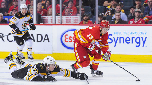 CALGARY, AB - OCTOBER 17: Johnny Gaudreau #13 of the Calgary Flames carries the puck past Charlie McAvoy #73 of the Boston Bruins during an NHL game at Scotiabank Saddledome on October 17, 2018 in Calgary, Alberta, Canada.