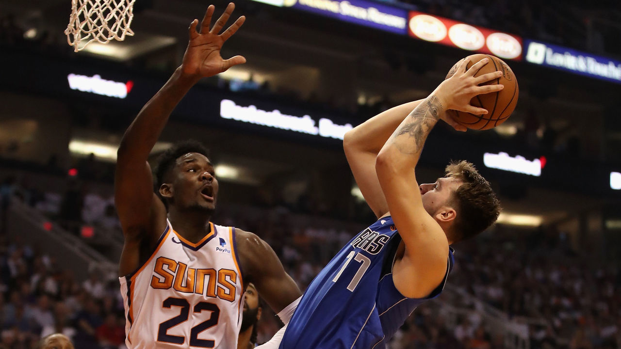 PHOENIX, AZ - OCTOBER 17: Luka Doncic #77 of the Dallas Mavericks attempts a shot against Deandre Ayton #22 of the Phoenix Suns during the first half of the NBA game at Talking Stick Resort Arena on October 17, 2018 in Phoenix, Arizona. The Suns defeated defeated the Mavericks 121-100.