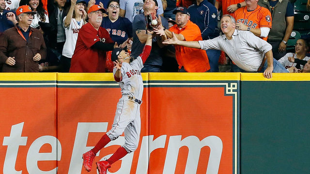 HOUSTON, TX - OCTOBER 17: A fan interferes with Mookie Betts #50 of the Boston Red Sox as he attempts to catch a ball hit by Jose Altuve #27 of the Houston Astros (not pictured) in the first inning during Game Four of the American League Championship Series at Minute Maid Park on October 17, 2018 in Houston, Texas.