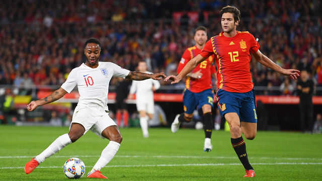 SEVILLE, SPAIN - OCTOBER 15: Raheem Sterling of England scores his team's first goal as Marcos Alonso of Spain looks on during the UEFA Nations League A Group Four match between Spain and England at Estadio Benito Villamarin on October 15, 2018 in Seville, Spain.