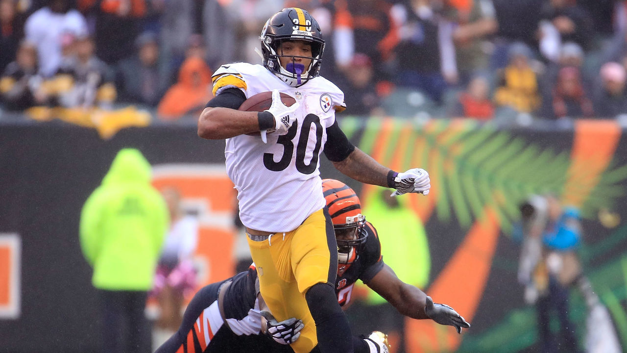 CINCINNATI, OH - OCTOBER 14: James Conner #30 of the Pittsburgh Steelers breaks a tackle by Geno Atkins #97 of the Cincinnati Bengals during the third quarter at Paul Brown Stadium on October 14, 2018 in Cincinnati, Ohio.