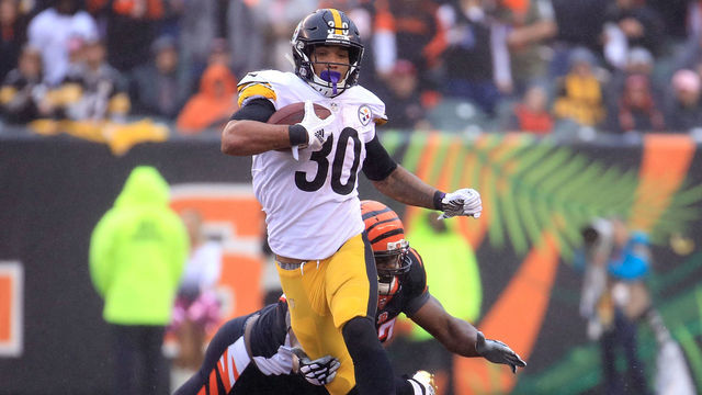 CINCINNATI, OH - OCTOBER 14: James Conner #30 of the Pittsburgh Steelers breaks a tackle by Geno Atkins #97 of the Cincinnati Bengals during the third quarter at Paul Brown Stadium on October 14, 2018 in Cincinnati, Ohio.