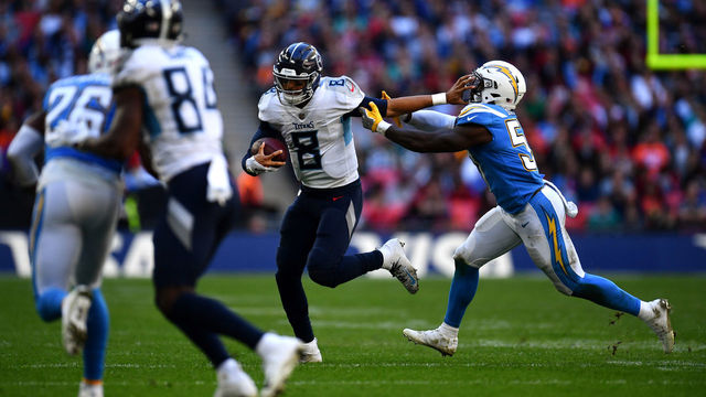 LONDON, ENGLAND - OCTOBER 21: Marcus Mariota (8) of the Tennessee Titans holds off Jatavis Brown (57) of the Los Angeles Chargers during the Tennessee Titans against the Los Angeles Chargers at Wembley Stadium on October 21, 2018 in London, England.