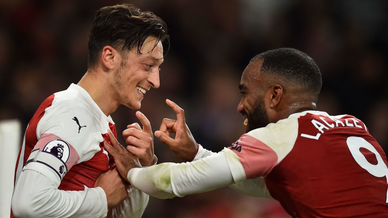 Arsenal's German midfielder Mesut Ozil (L) celebrates with Arsenal's French striker Alexandre Lacazette after scoring their first goal during the English Premier League football match between Arsenal and Leicester City at the Emirates Stadium in London on October 22, 2018.