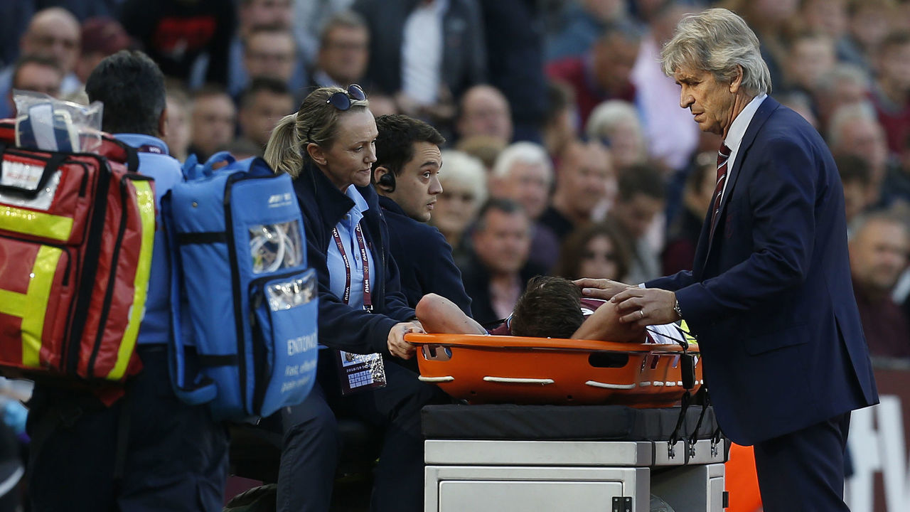 West Ham United's Chilean Manager Manuel Pellegrini (R) checks on West Ham United's Ukrainian striker Andriy Yarmolenko after he is stretchered off through injury during the English Premier League football match between West Ham United and Tottenham Hotspur at the London Stadium, in east London on October 20, 2018.