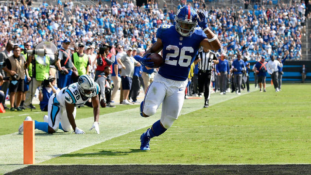CHARLOTTE, NC - OCTOBER 07: Saquon Barkley #26 of the New York Giants scores a 57-yard receiving touchdown from Odell Beckham Jr. #13 against the Carolina Panthers in the second quarter during their game at Bank of America Stadium on October 7, 2018 in Charlotte, North Carolina.