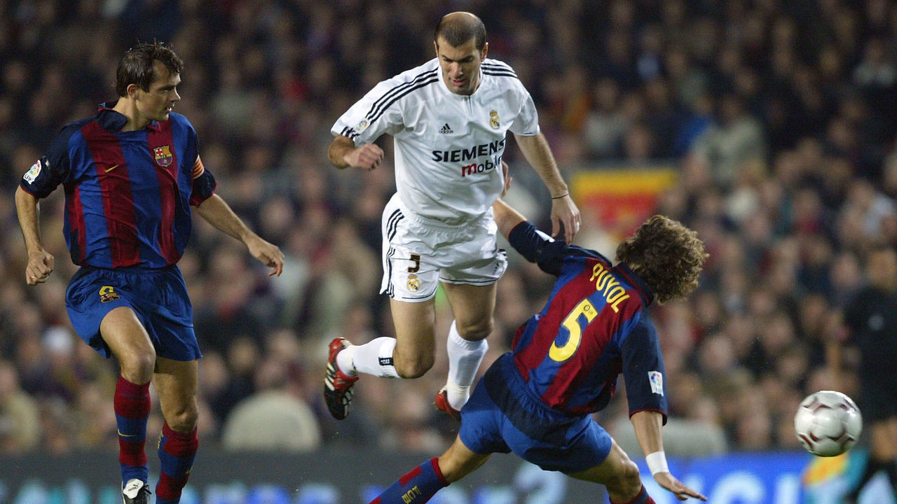 BARCELONA, SPAIN - DECEMBER 6: Zinedine Zidane of Real Madrid is challenged by Puyol and Philip Cocu of Barcelona during the Spanish Primera Liga match between Barcelona and Real Madrid at the Nou Camp Stadium on December 6, 2003 in Barcelona, Spain.