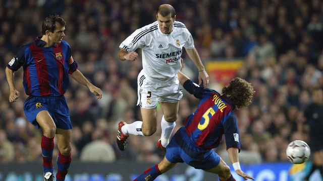 BARCELONA, SPAIN - DECEMBER 6: Zinedine Zidane of Real Madrid is challenged by Puyol and Philip Cocu of Barcelona during the Spanish Primera Liga match between Barcelona and Real Madrid at the Nou Camp Stadium on December 6, 2003 in Barcelona, Spain.