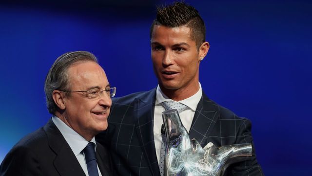 Real Madrid's Portuguese forward Cristiano Ronaldo (R) holds his trophy of Best Men's player in Europe next to Real Madrid President Florentino Perez at the end of the UEFA Champions League Group stage draw ceremony, on August 25, 2016 in Monaco. / AFP / VALERY HACHE