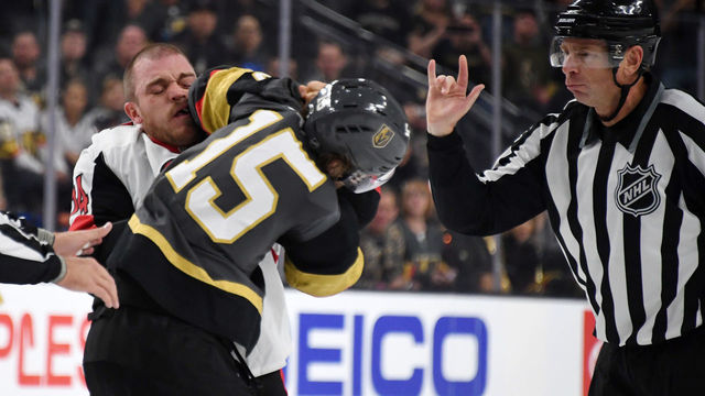 LAS VEGAS, NEVADA - OCTOBER 28: Mark Borowiecki #74 of the Ottawa Senators and Jon Merrill #15 of the Vegas Golden Knights fight as linesman Pierre Racicot moves in during the first period of their game at T-Mobile Arena on October 28, 2018 in Las Vegas, Nevada. The Golden Knights defeated the Senators 4-3 in overtime.