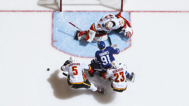 TORONTO, ON - OCTOBER 29: John Tavares #91 of the Toronto Maple Leafs battles in front of the net against Mark Giordano #5 of the Calgary Flames Sean Monahan #23 and Mike Smith #41 during the third period at the Scotiabank Arena on October 29, 2018 in Toronto, Ontario, Canada.