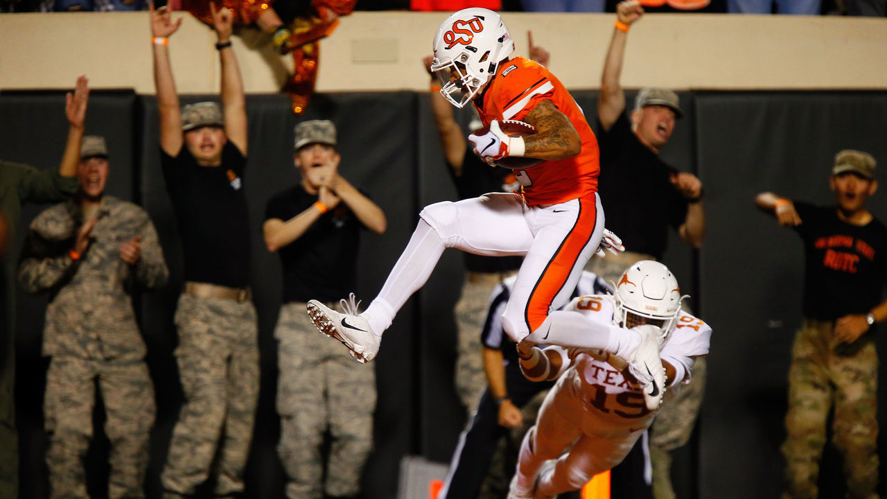 STILLWATER, OK - OCTOBER 27: Wide receiver Tylan Wallace #2 of the Oklahoma State Cowboys leaps into the end zone for a 36-yard catch and touchdown against defensive back Brandon Jones #19 of the Texas Longhorns in the second quarter on October 27, 2018 at Boone Pickens Stadium in Stillwater, Oklahoma. Oklahoma State leads 31-14 at the half.