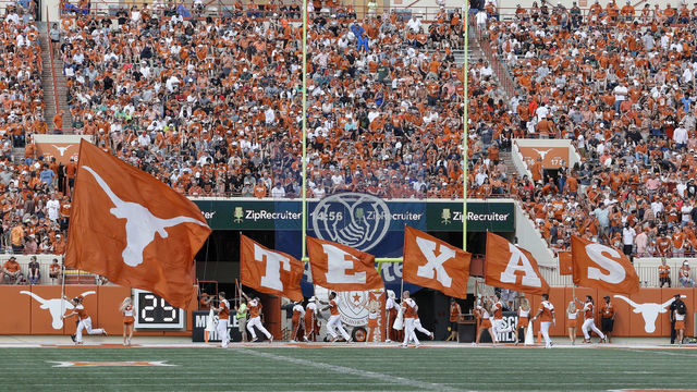 AUSTIN, TX - OCTOBER 13: The Texas Longhorns cheerleaders run with flags after a touchdown in the second half against the Baylor Bears at Darrell K Royal-Texas Memorial Stadium on October 13, 2018 in Austin, Texas.