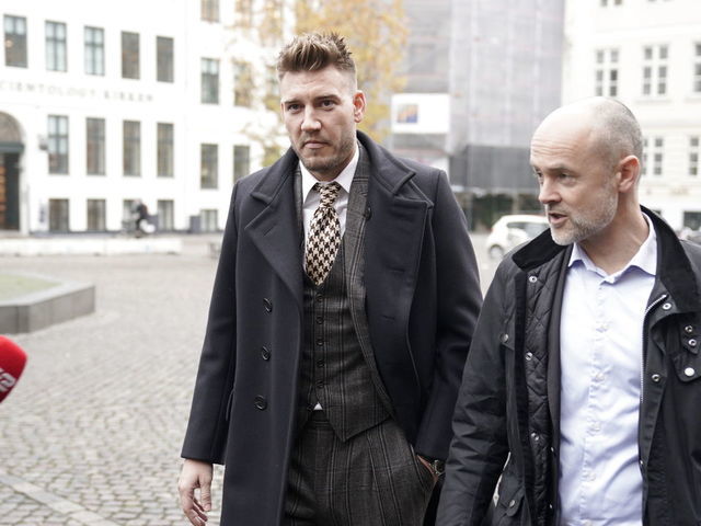 Rosenborg's Danish football player Nicklas Bendtner and lawyer Anders Nemeth talk to the media as they arrive for a hearing at Copenhagen City Council on November 2, 2018. - Nicklas Bendtner has been charged with violence against a taxi driver in Copenhagen while the driver has been charged with attempted violence.