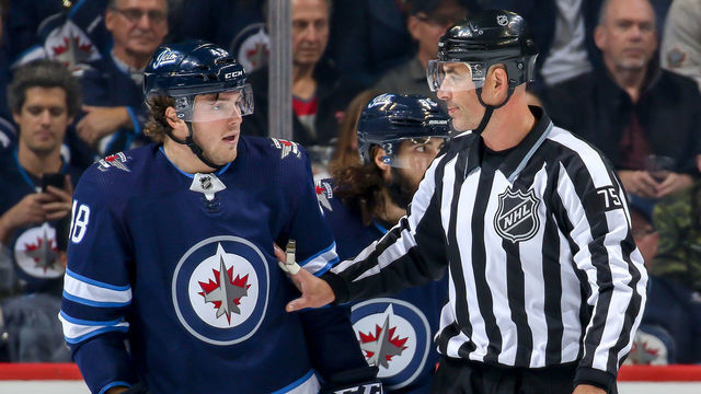 WINNIPEG, MB - OCTOBER 18: Linesman Derek Amell #75 holds back Brendan Lemieux #48 of the Winnipeg Jets during a first period stoppage in play against the Vancouver Canucks at the Bell MTS Place on October 18, 2018 in Winnipeg, Manitoba, Canada.