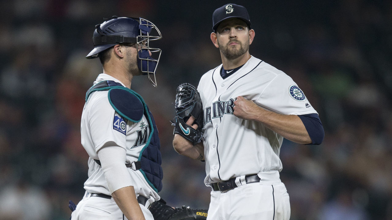 SEATTLE, WA - AUGUST 10: Starting pitcher James Paxton #65 of the Seattle Mariners grabs his jersey while meeting at the pitcher's mound with catcher Mike Zunino #3 of the Seattle Mariners shortly before Paxton left with a left pectoral strain during the sixth inning of a game against the Los Angeles Angels of Anaheim at Safeco Field on August 10, 2017 in Seattle, Washington. The Angels won the game 6-3.