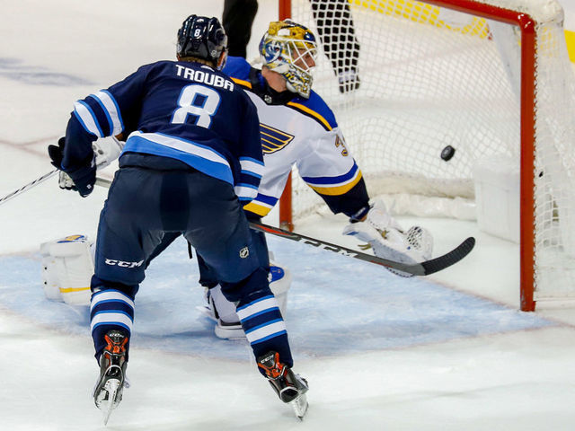 WINNIPEG, MB - OCTOBER 22: Jacob Trouba #8 of the Winnipeg Jets shoots the puck past goaltender Jake Allen #34 of the St. Louis Blues for the overtime winner at the Bell MTS Place on October 22, 2018 in Winnipeg, Manitoba, Canada. The Jets defeated the Blues 5-4.