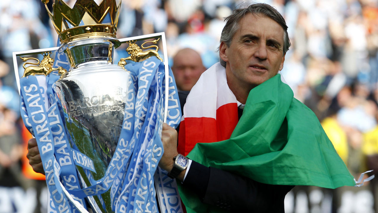 Manchester City manager Roberto Mancini celebrates with the trophy during the Barclays Premier League match at the Etihad Stadium, Manchester.