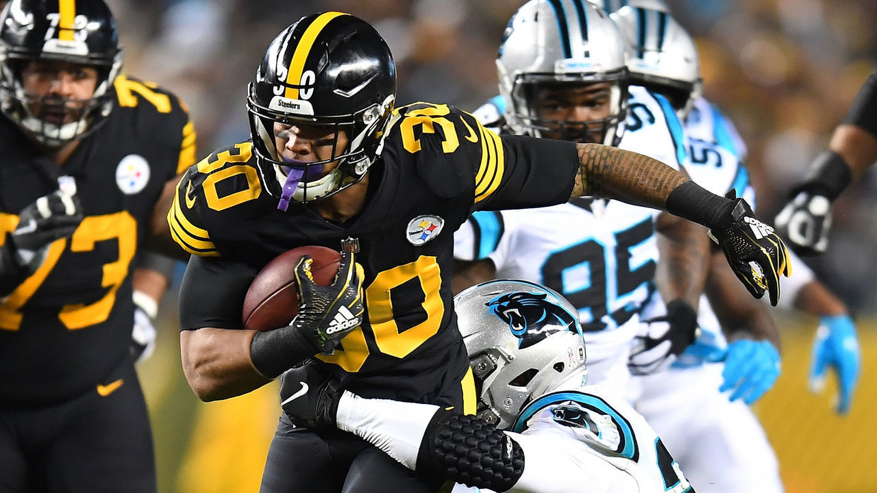 PITTSBURGH, PA - NOVEMBER 08: James Conner #30 of the Pittsburgh Steelers carries the ball against Eric Reid #25 of the Carolina Panthers during the first half in the game at Heinz Field on November 8, 2018 in Pittsburgh, Pennsylvania.