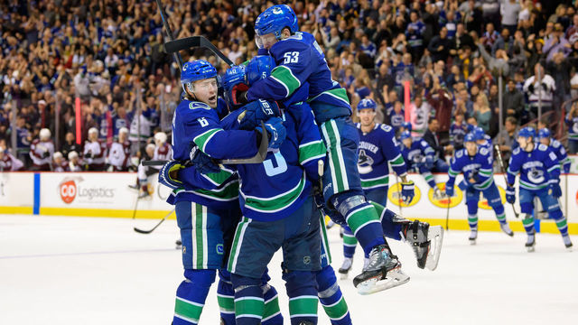 VANCOUVER, BC - NOVEMBER 02: Vancouver Canucks defenseman Derrick Pouliot (5) celebrates with right wing Brock Boeser (6) center Bo Horvat (53) and center Elias Pettersson (40) after scoring a goal in overtime during their NHL game against the Colorado Avalanche at Rogers Arena on November 2, 2018 in Vancouver, British Columbia, Canada. Vancouver won 7-6.