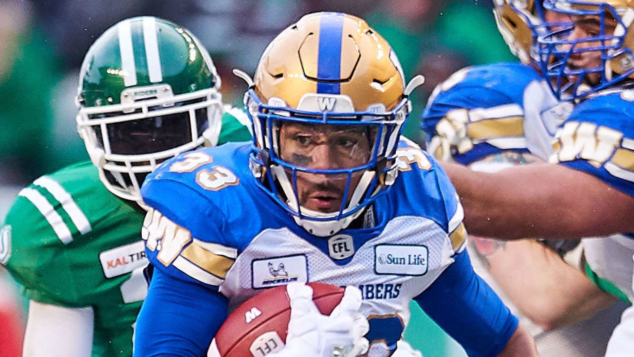 REGINA, SK - NOVEMBER 11: Andrew Harris #33 of the Winnipeg Blue Bombers looks to avoid Derrick Moncrief #42 of the Saskatchewan Roughriders during a run in the first half of the western semi final game between the Winnipeg Blue Bombers and Saskatchewan Roughriders at Mosaic Stadium on November 11, 2018 in Regina, Canada.