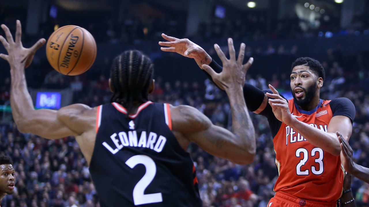 TORONTO, ON - NOVEMBER 12: Anthony Davis #23 of the New Orleans Pelicans passes the ball as Kawhi Leonard #2 and Pascal Siakam #43 of the Toronto Raptors defend during the first half of an NBA game at Scotiabank Arena on November 12, 2018 in Toronto, Canada.