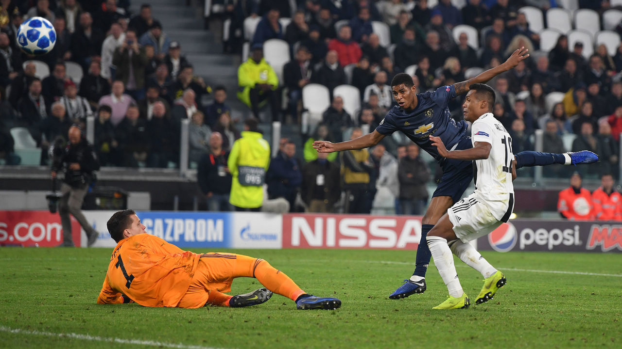 TURIN, ITALY - NOVEMBER 07: Marcus Rashford of Manchester United fires in a shot past Wojciech Szczesny as Alex Sandro challenges during the UEFA Champions League Group H match between Juventus and Manchester United at Allianz Stadium on November 07, 2018 in Turin, Italy.