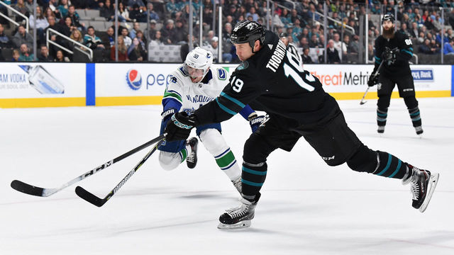 SAN JOSE, CA - NOVEMBER 23: Joe Thornton #19 of the San Jose Sharks takes a shot on goal against Tim Schaller #59 of the Vancouver Canucks at SAP Center on November 23, 2018 in San Jose, California