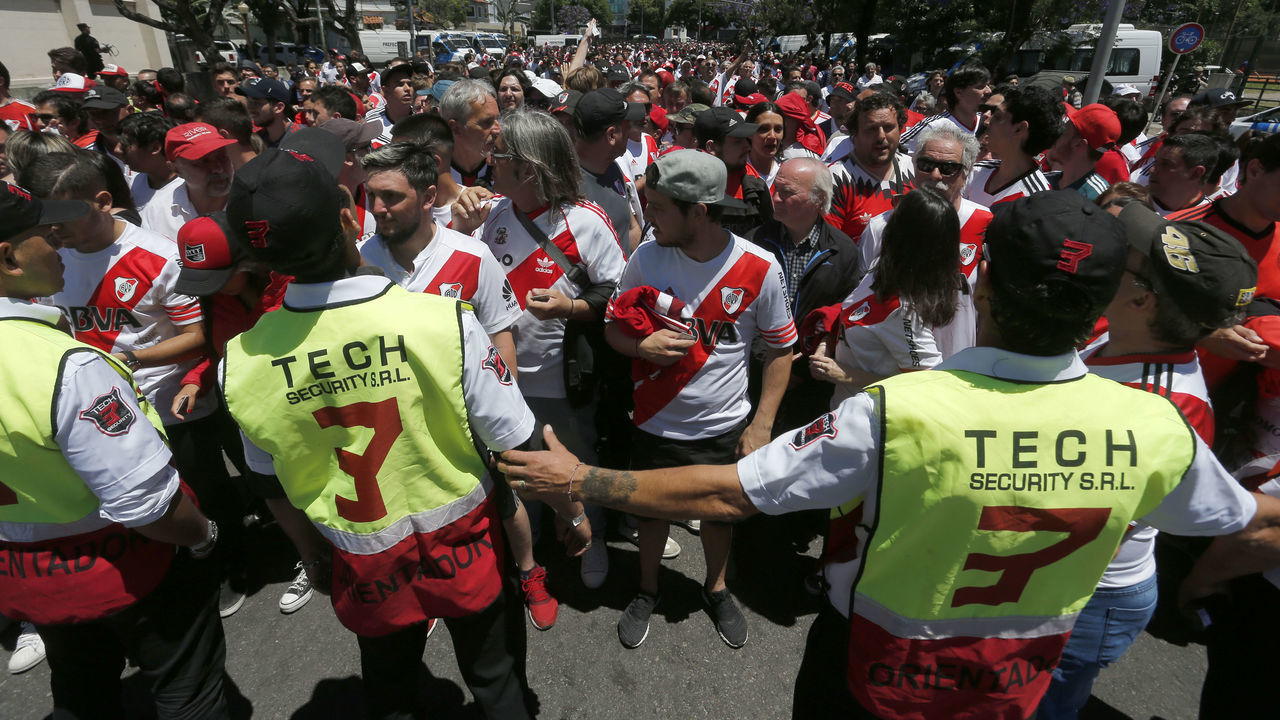 BUENOS AIRES, ARGENTINA - NOVEMBER 25: Police officers look at River fans on their way to the stadium prior the second leg of the final of Copa CONMEBOL Libertadores 2018 between River Plate and Boca Juniors at Estadio Monumental Antonio Vespucio Liberti on November 25, 2018 in Buenos Aires, Argentina. The match was suspended yesterday due to the attacks suffered by players of Boca Juniors on their arrival to the satdium and was rescheduled for today.