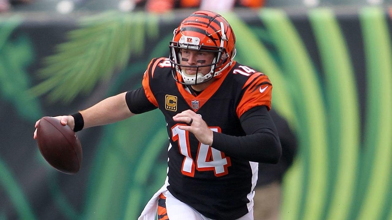 CINCINNATI, OH - NOVEMBER 25: Andy Dalton #14 of the Cincinnati Bengals slips out of an attempted tackle by Myles Garrett #95 of the Cleveland Browns during the second quarter at Paul Brown Stadium on November 25, 2018 in Cincinnati, Ohio.