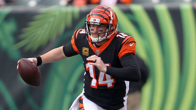 CINCINNATI, OH - NOVEMBER 25: Andy Dalton #14 of the Cincinnati Bengals slips out of an attempted tackle by Myles Garrett #95 of the Cleveland Browns during the second quarter at Paul Brown Stadium on November 25, 2018 in Cincinnati, Ohio.
