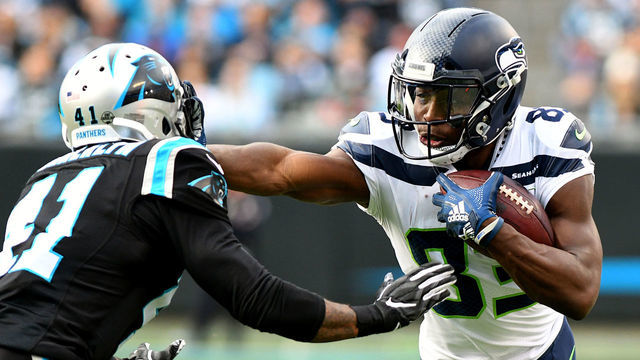 CHARLOTTE, NC - NOVEMBER 25: Seattle Seahawks wide receiver David Moore (83) stiff arms Carolina Panthers defensive back Captain Munnerlyn (41) during the play on November 25, 2018 at Bank of America Stadium in Charlotte, NC.